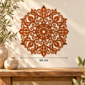 Grote cortenstalen mandala aan een lichte muur, met een horizontale maatlijn van 60 cm.