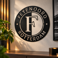Zwart metalen Feyenoord logo als sfeervolle wanddecoratie aan de muur in een voetbalkamer. Stoere muurdecoratie voor Feyenoord supporters.