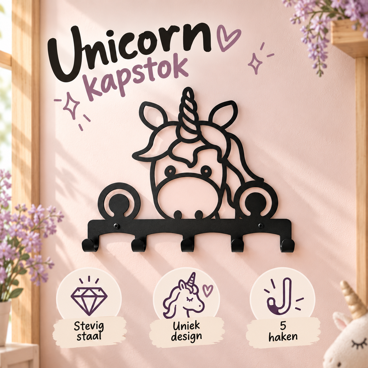 Zwarte unicorn kapstok met iconen en de teksten stevig staal, uniek design en vijf haken tegen een zachtroze muur.
